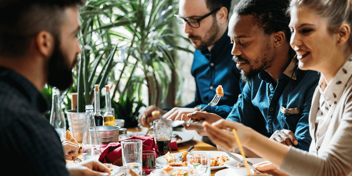 Team junger Arbeitskolleg/-innen beim gemeinsamen Essen 