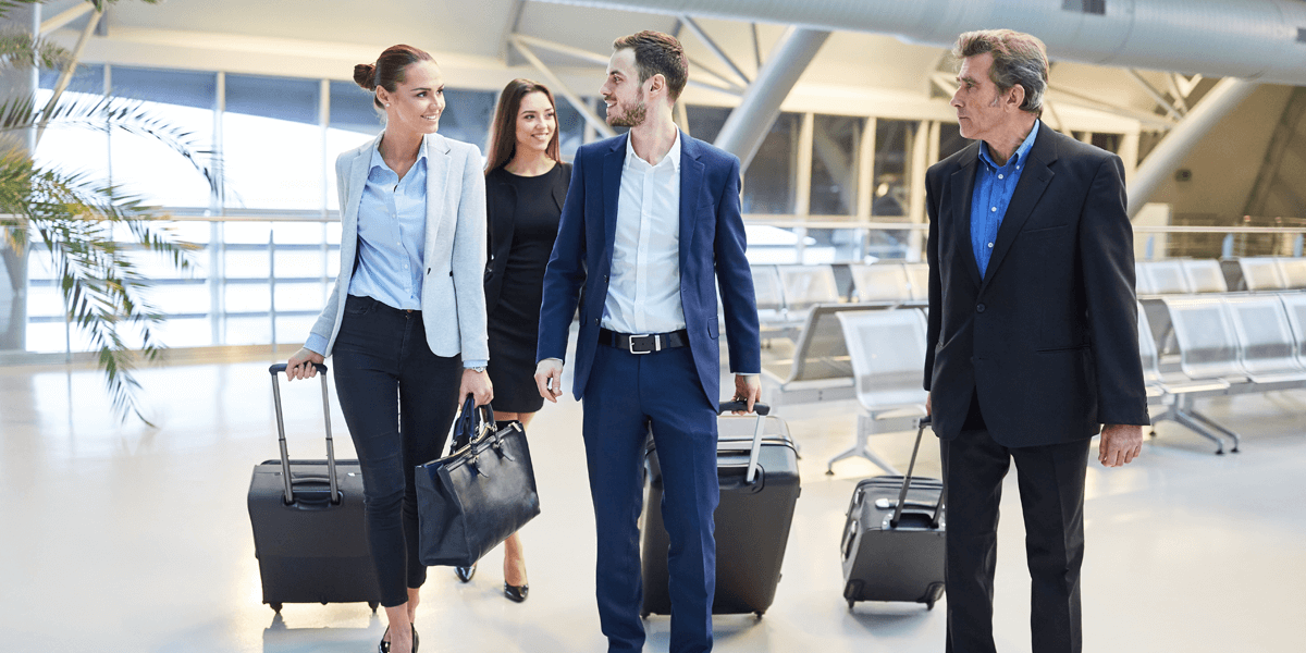 Gruppe von Geschäftsleuten auf Dienstreise unterhalten sich am Flughafen