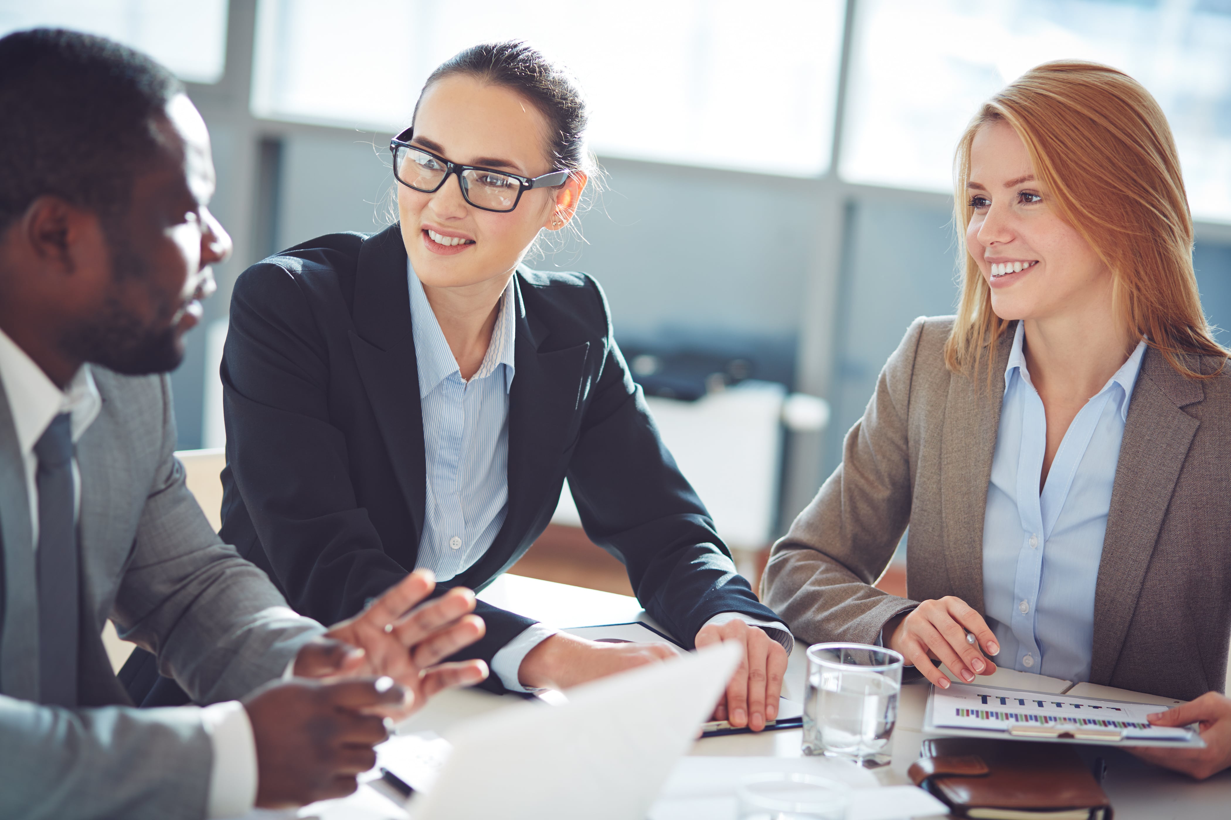 Diverses Team in Business Look führen ein Meeting-Gespräch und besprechen Unterlagen