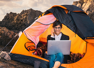 Frau im Zelt arbeitet am Laptop – Akademie Herkert